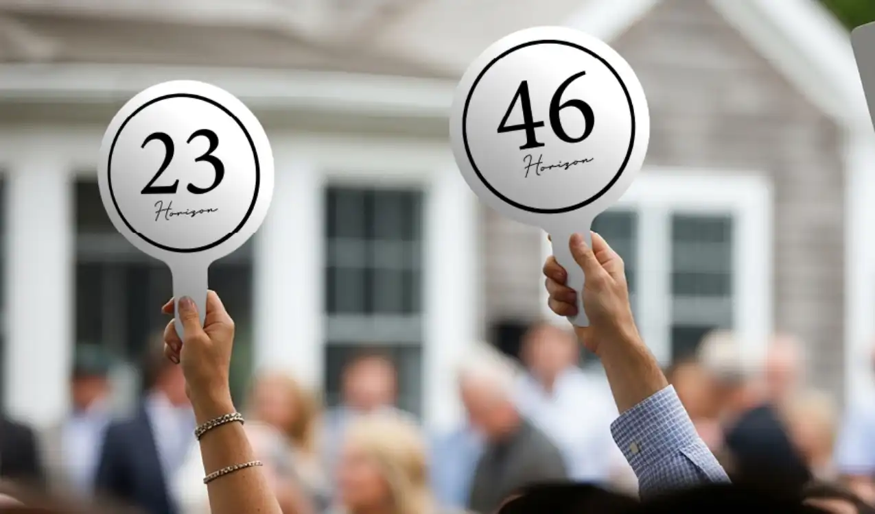 Stamp duty on auction property — bidder raising paddle at property auction in UK with solicitor reviewing SDLT obligations