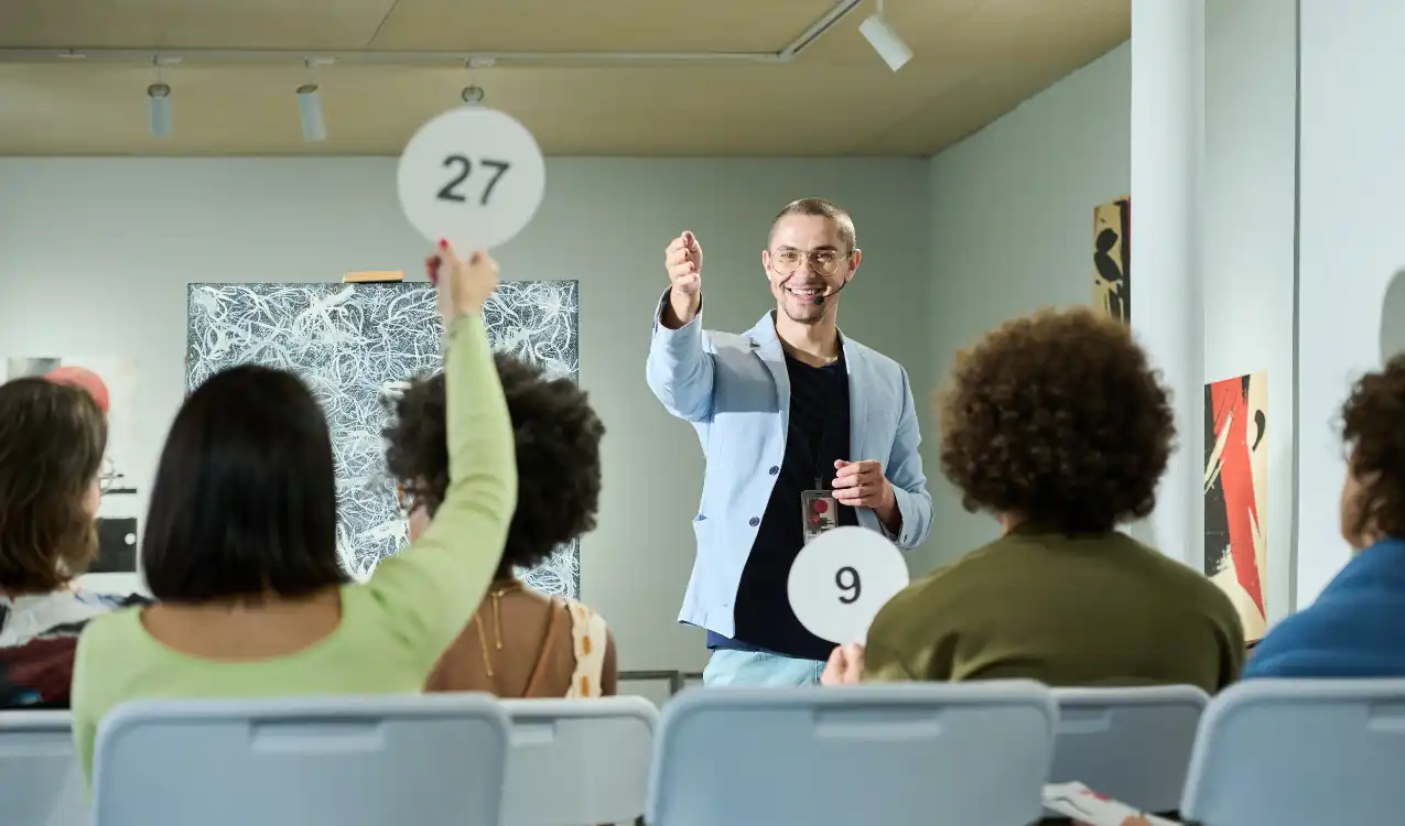 Selling at auction UK – bidders competing at a property auction event