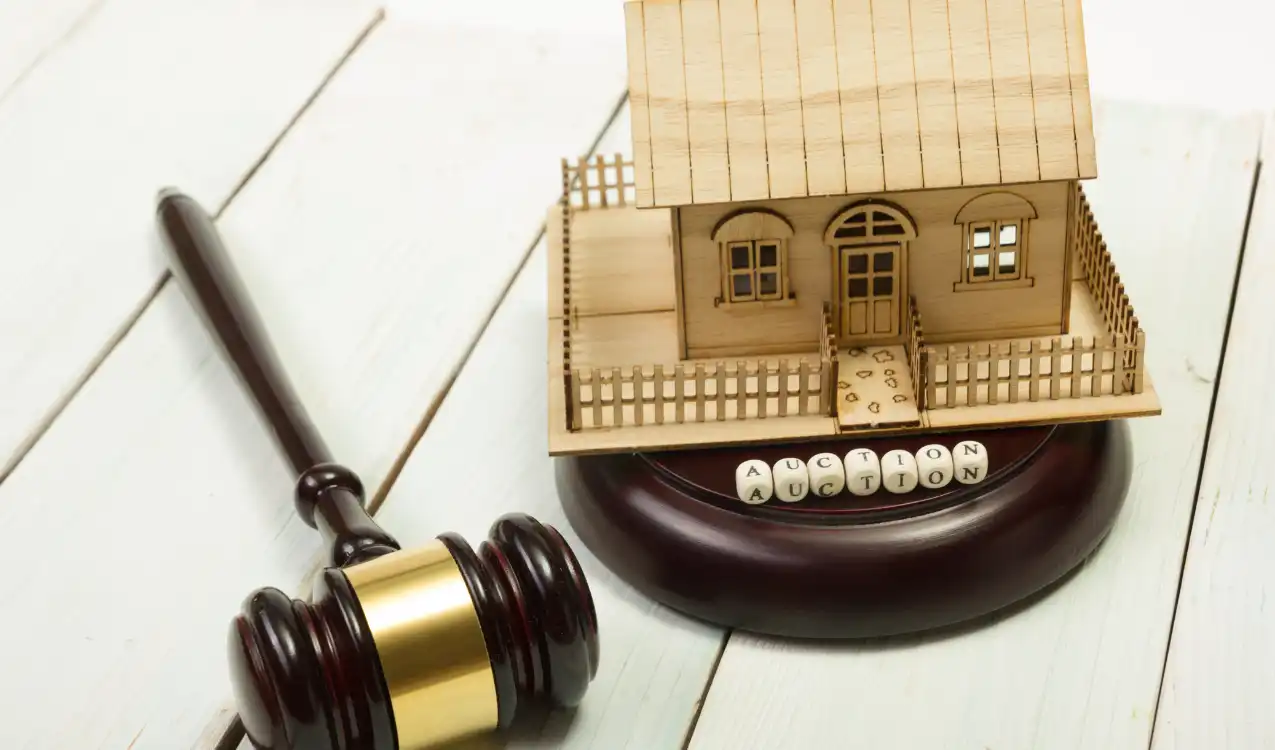Auction reserve price and guide price relationship — auctioneer at podium with gavel showing hammer price at auction board and bidding lot details UK property auction