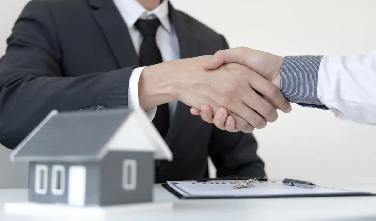 Hammer price at auction UK — successful buyer after winning property auction lot shaking hands with auctioneer alongside auction guide price and reserve price explained